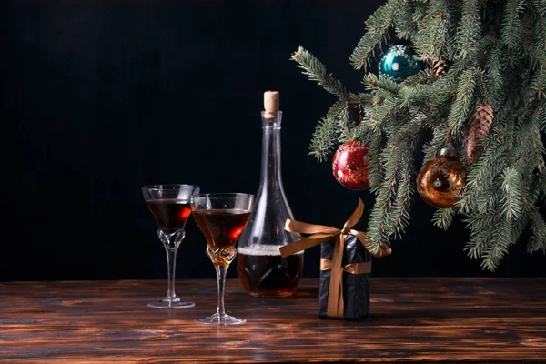 Siyah arka planda çok renkli cam toplarla süslenmiş kozalaklı Noel ağacı