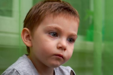 İki yaşındaki güzel bebeğin kaşıkla yemek yemesine yakın durun.