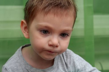 İki yaşındaki güzel bebeğin kaşıkla yemek yemesine yakın durun.