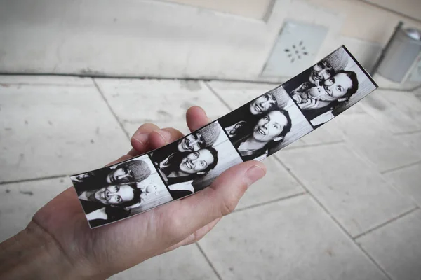 Genç bir çiftin fotoğraflarını bir Photo booth şerit tutan el