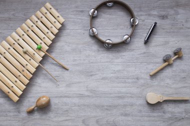 Metin için yer ile gri bir ahşap tabloda çeşitli vurmalı çalgılar. Müzik sınıfı arka plan