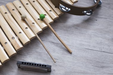 Metin için yer ile gri bir ahşap tabloda çeşitli vurmalı çalgılar. Müzik sınıfı arka plan
