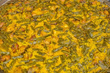Paella. İspanyol yemeği. Tavuk, tavşan, yeşil fasulye, enginar ile sarı pirinç