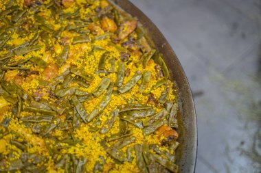 Paella. İspanyol yemeği. Tavuk, tavşan, yeşil fasulye, enginar ile sarı pirinç