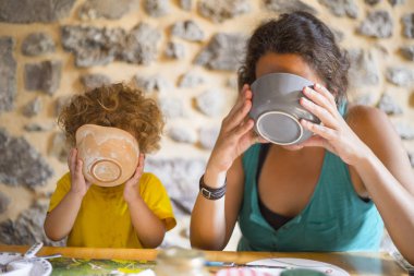 Anne ve kızı onların kase iki eliyle tutarak ve içme kahvaltı masasında. Tanıdık sabah