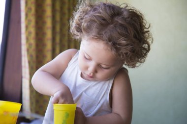 Hamur bir kavanoz ile oynarken kıvırcık saçlı küçük güzel beyaz toddler