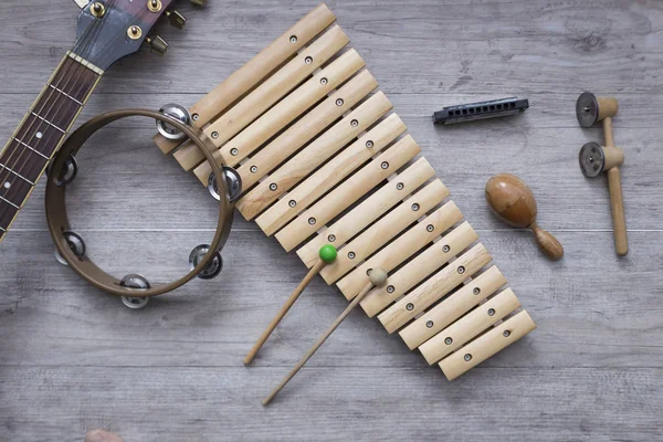 Metin için yer ile gri bir ahşap tabloda çeşitli vurmalı çalgılar. Müzik sınıfı arka plan