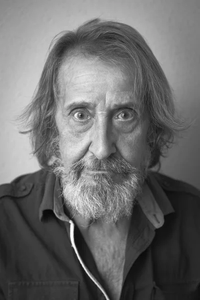 Black and white portrait of old man with long hair and beard