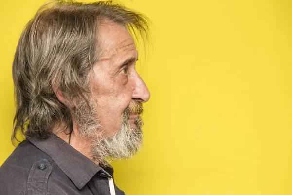 portrait of old man with long hair and beard against yellow background