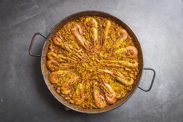 Bir Paella pic kadar kapatın. İspanyol yemeği. Karides ve mürekkep ile sarı pirinç