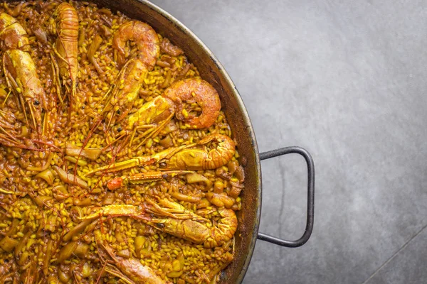 Bir Paella pic kadar kapatın. İspanyol yemeği. Karides ve mürekkep ile sarı pirinç