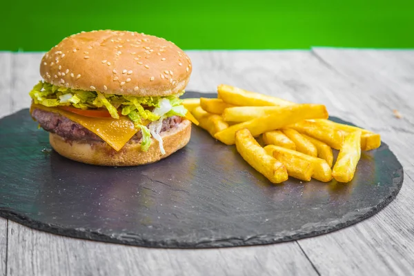homemade hamburger with cheddar cheese, tomato and lettuce, served with fries
