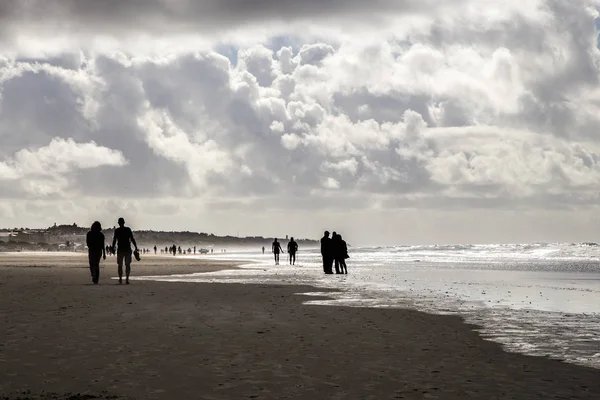 Wunderschöner Sandstrand Mit Silhouetten Von Menschen Und Meereswellen — Stockfoto