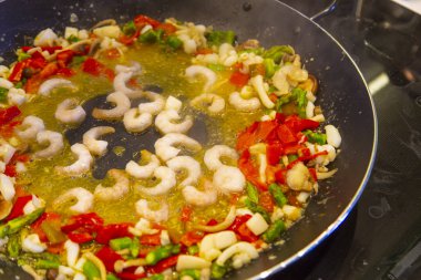 Asparragus, kalamar, biber ve karides ile bir paella tavada pişirme. İspanyol cousine