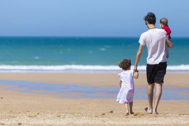 mutlu bir aile ile bebek ve küçük kızı deniz dalgaları arıyorum Genç Baba, sakin ol