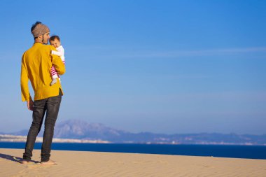 Genç baba bebek kızı deniz yürüyüş ile mutlu bir aile sakin ol.