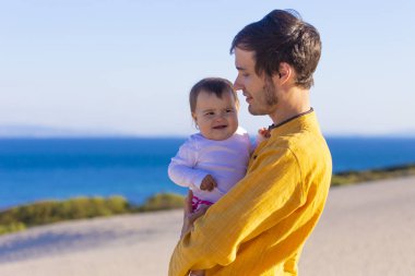 Genç baba bebek kızı deniz yürüyüş ile mutlu bir aile sakin ol.