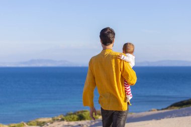 Genç baba bebek kızı deniz yürüyüş ile mutlu bir aile sakin ol.