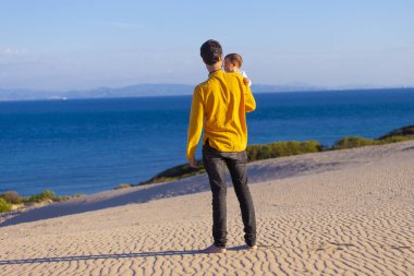 Genç baba bebek kızı deniz yürüyüş ile mutlu bir aile sakin ol.