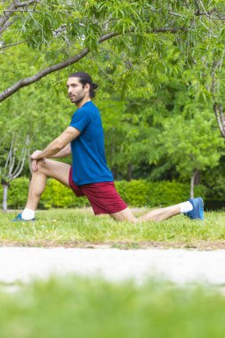 Genç adam yaz parkta germe