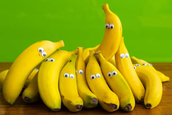 funny pack of yellow bananas with cartoon plastic eyes. Food for children