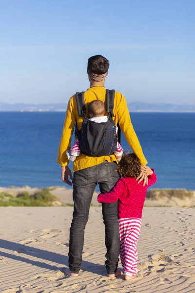 Genç Baba ile bebek ve küçük kıza karşı mavi gökyüzü deniz plaj