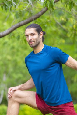 Genç adam yaz parkta germe