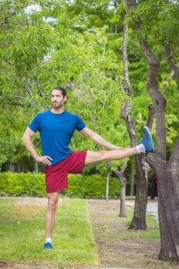 Genç adam yaz parkta germe