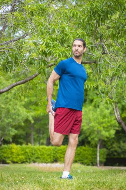 Genç adam yaz parkta germe