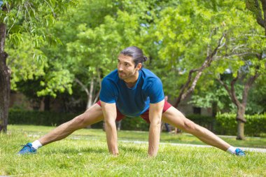 Genç adam yaz parkta germe