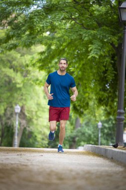 çekici genç adam parkta, sağlıklı bir yaşam tarzı çalışan uygun