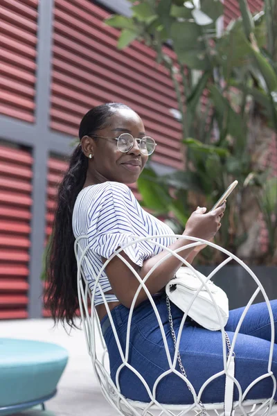 Atractiva Mujer Africana Joven Terraza Moderna Mientras Utiliza Teléfono Inteligente —  Fotos de Stock