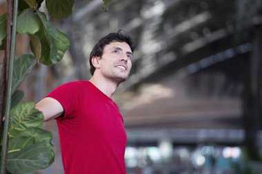 Tren istasyonunda kırmızı t-shirt ile giyinmiş genç adam