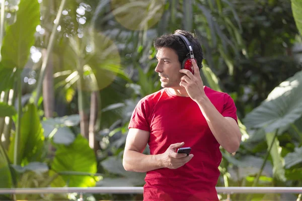 Joven Con Auriculares Smartphone Vestido Con Camiseta Roja Sobre Fondo —  Fotos de Stock