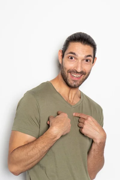 Expressive young man on white background pointing at himself — Stock Photo, Image