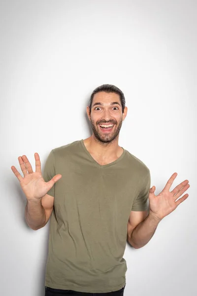 Expressive young man with his hands in the air and surprising face — Stock Photo, Image