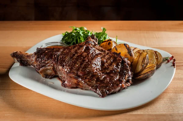 Perfekt kokt saftig biff med salat på en rett brun tallerken ligger på bordet. . – stockfoto