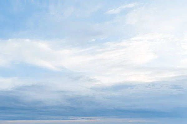 Blue sky with white clouds. Background from the cloudy sky. Long and stretched clouds in the sky.Blue sky with long clouds for background.