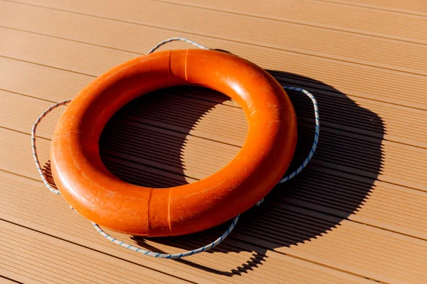 Uma bóia salva-vidas laranja está sobre um fundo rachado. Conceito de segurança da água — Fotografia de Stock