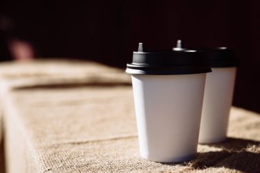 Çuval bezinde iki kağıt kahve fincanı. Bir fincan kahve çekirdeği.