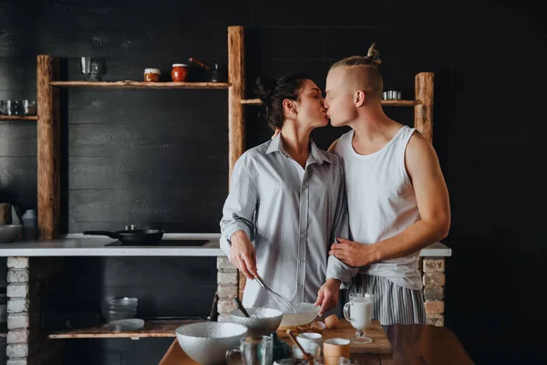Young couple in love cook healthy food in the kitchen together. While kissing each other