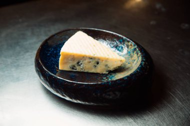 Bir parça küflü peynir servis edilmeye hazır bir tabakta yatıyor..