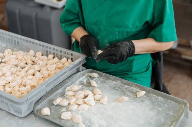 Çiğ hamur köftesi. Pişirme süreci. Eldivenli bir aşçı onları yontuyor. Rus ulusal yemeği..