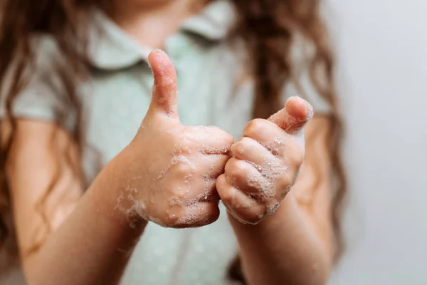 Children\'s hands in soapy foam. Remember to wash their hands