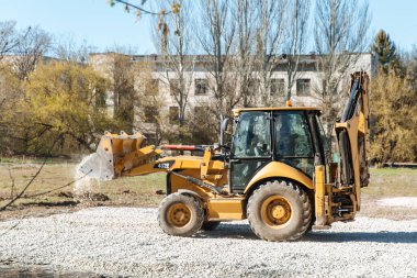Dneprorudnoe / Ukrayna - Nisan 08 2020: Bir traktör kovadan çakıl döktü