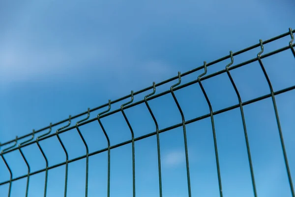 蓝色天空下的钢制铁栅栏 — 图库照片