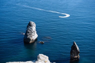 Her tarafında suyla çevrili büyük bir taş var. Deniz manzarası.