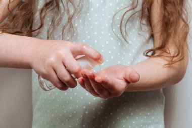 Çocuk el dezenfektanı kullanıyor. Coronavirus COVID-19 salgın enfeksiyonu önleme ve kontrol. Hijyen ve sağlık hizmetleri kavramı