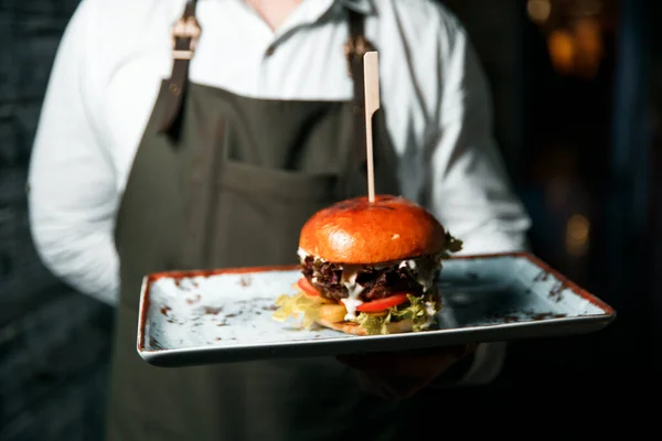 Taze lezzetli hamburger, servis etmeye hazır tabakta yatıyor..
