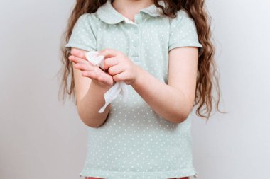 Çocuk ellerini ıslak antibakteriyel mendil ile siler. Virüs mikroplarıyla mücadele.